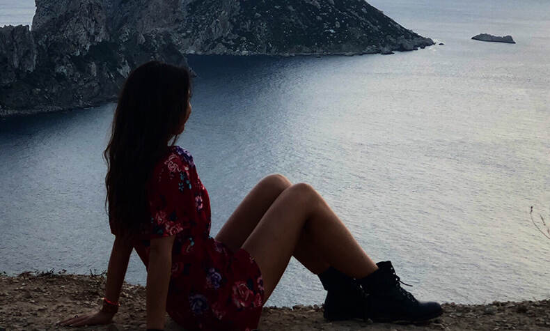 Foto van Nadine, zittend op het strand met uitzicht op een eiland